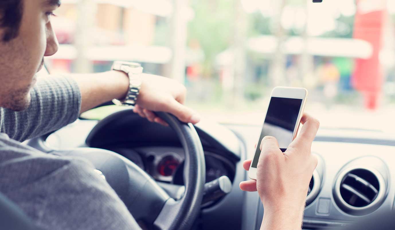 man checking phone in a car